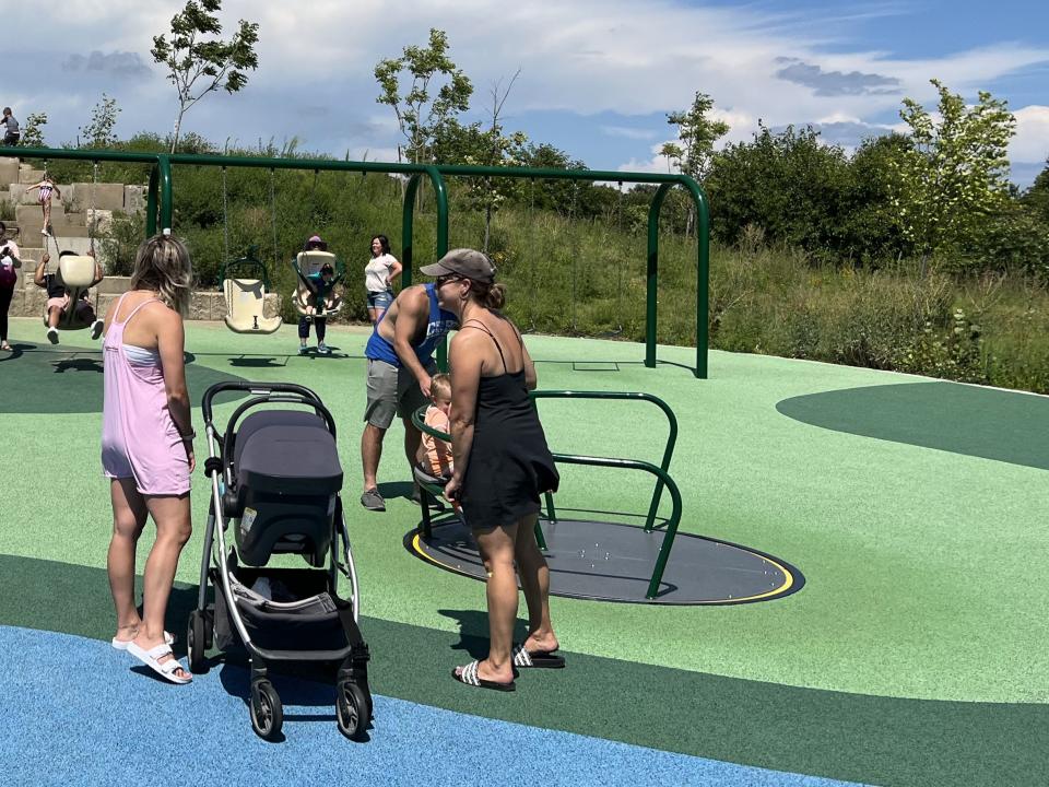 In this undated photo, families play at a Carmel, Indiana park designed by SmithGroup that includes universally designed equipment including an at-grade merry-go-round.