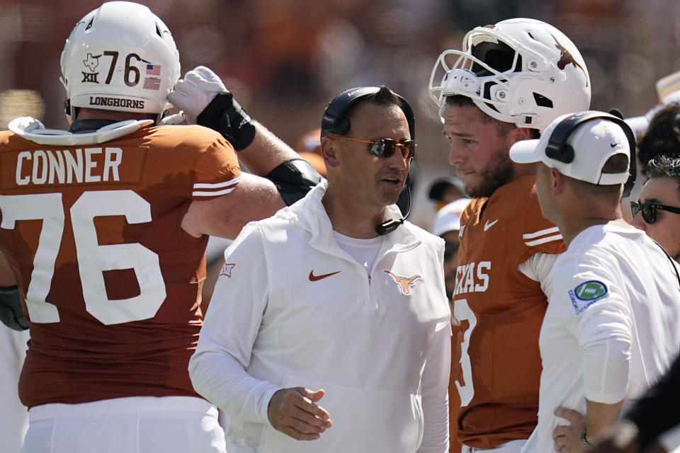 Texas head coach Steve Sarkisian, center, talks with quarterback Quinn Ewers (3) during the first half of an NCAA college football game in Austin, Texas, Saturday, Sept. 30, 2023. (AP Photo/Eric Gay)