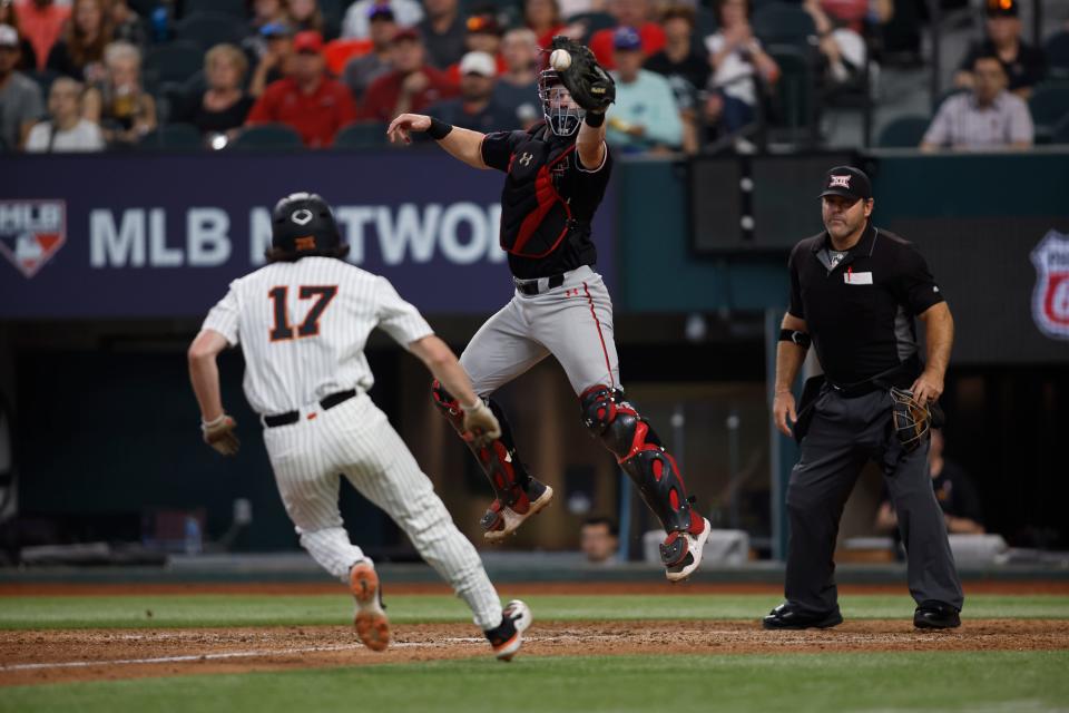 Texas Tech catcher Hudson White reaches for a ball as Oklahoma State's Tyler Wulfert (17) comes home during a Big 12 tournament bracket final Saturday at Globe Life Field in Arlington. Wulfert scored on the play and Oklahoma State won 8-1, forcing the if-necessary game later Saturday.