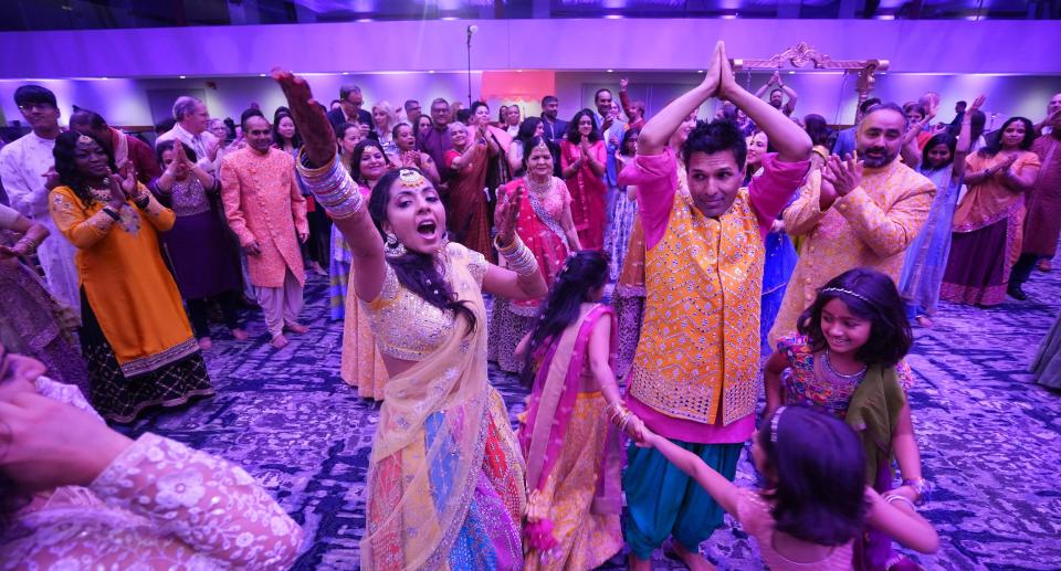 During their Garba & Dandiya Rass event for 450 people on June 9, children run around Rupal Ramesh Shah and Anup Kumar Kanodia as they enjoy folk dances from Gujarat, Rupal's ancestral home state in India. The Garba & Dandiya Rass event was held in the Hyatt Regency Ballroom.