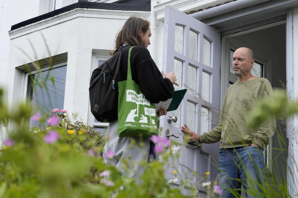 Councillor Raphael Hill, left, speaks to resident Roger Ballance as they canvass for The Green Party in the Round Hill Ward in Brighton, East Sussex, England, Wednesday, June 12, 2024. There’s lots of talk of change in Britain’s election campaign, but little talk about climate change. The U.K.’s July 4 vote to choose a new government comes after one of the wettest and warmest winters on record, part of trends scientists attribute to global warming. (AP Photo/Kirsty Wigglesworth)