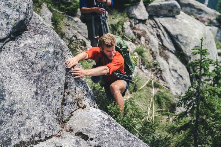 hiker climbing on a rock