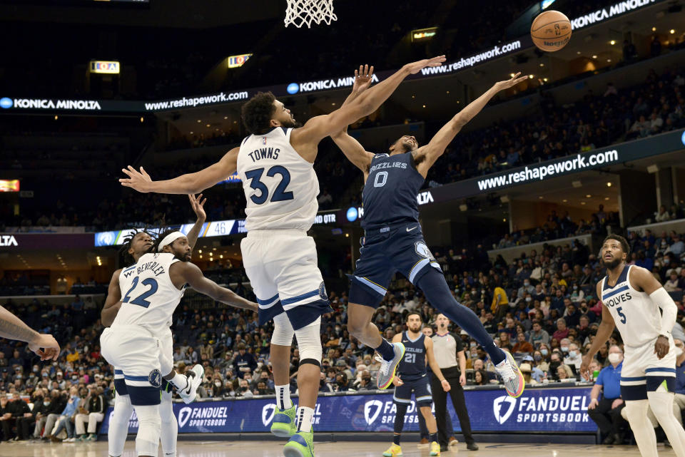 Minnesota Timberwolves center Karl-Anthony Towns (32) defends against Memphis Grizzlies guard De'Anthony Melton (0) in the first half of an NBA basketball game Thursday, Jan. 13, 2022, in Memphis, Tenn. (AP Photo/Brandon Dill)