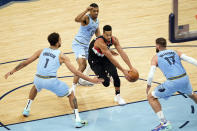 Portland Trail Blazers' CJ McCollum, center, drives between Memphis Grizzlies' defenders Kyle Anderson (1), De'Anthony Melton (0) and Jonas Valanciunas (17) in the second half of an NBA basketball game Wednesday, April 28, 2021, in Memphis, Tenn. (AP Photo/Mark Humphrey)