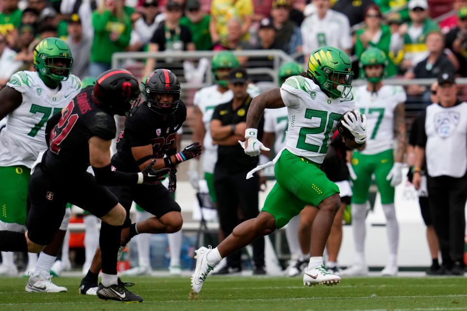 Oregon running back Jordan James, right, runs the ball on his way to a touchdown against Stanford during the first half of the game Saturday, Sept. 30, 2023, in Stanford, California.