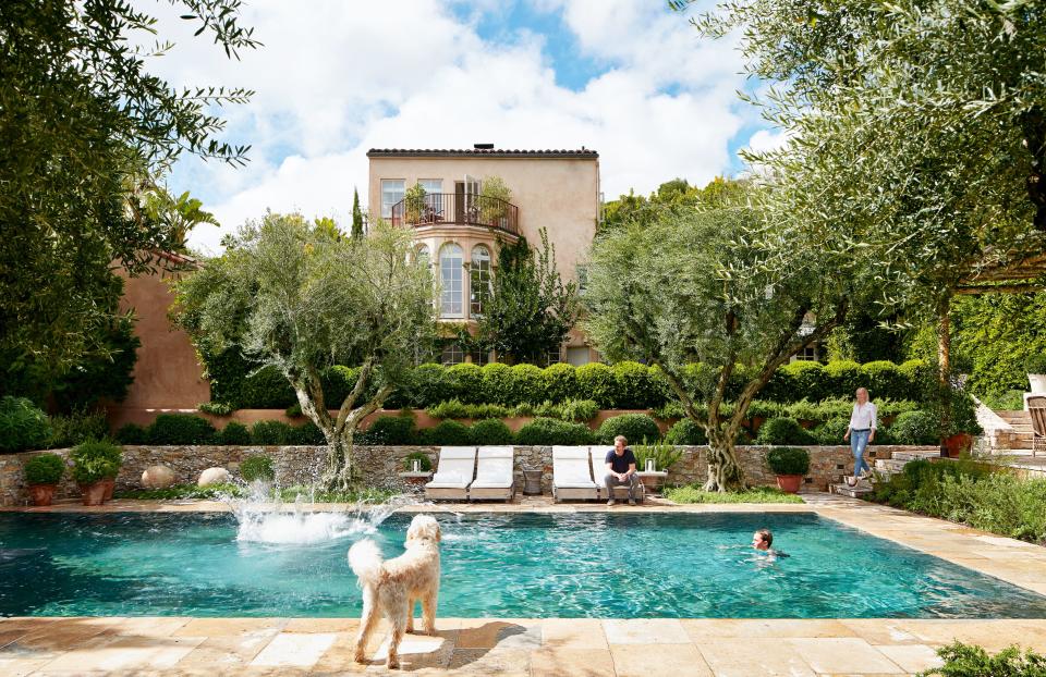 At their Los Angeles home, designers Alexandra (right) and Michael Misczynski of AD100 firm Atelier AM gather by the pool with their sons and dog.