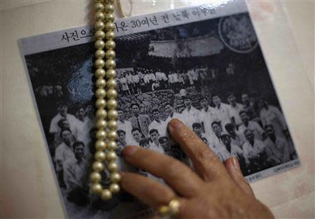 Kim Jeom-sun, 82, whose husband was abducted in 1972 by North Koreans, points at her husband in a picture taken with other abductees in 1974 at Myohyang mountain in North Korea, at her house in Busan, about 420 km (261 miles) southeast of Seoul October 28, 2013. REUTERS/Kim Hong-Ji