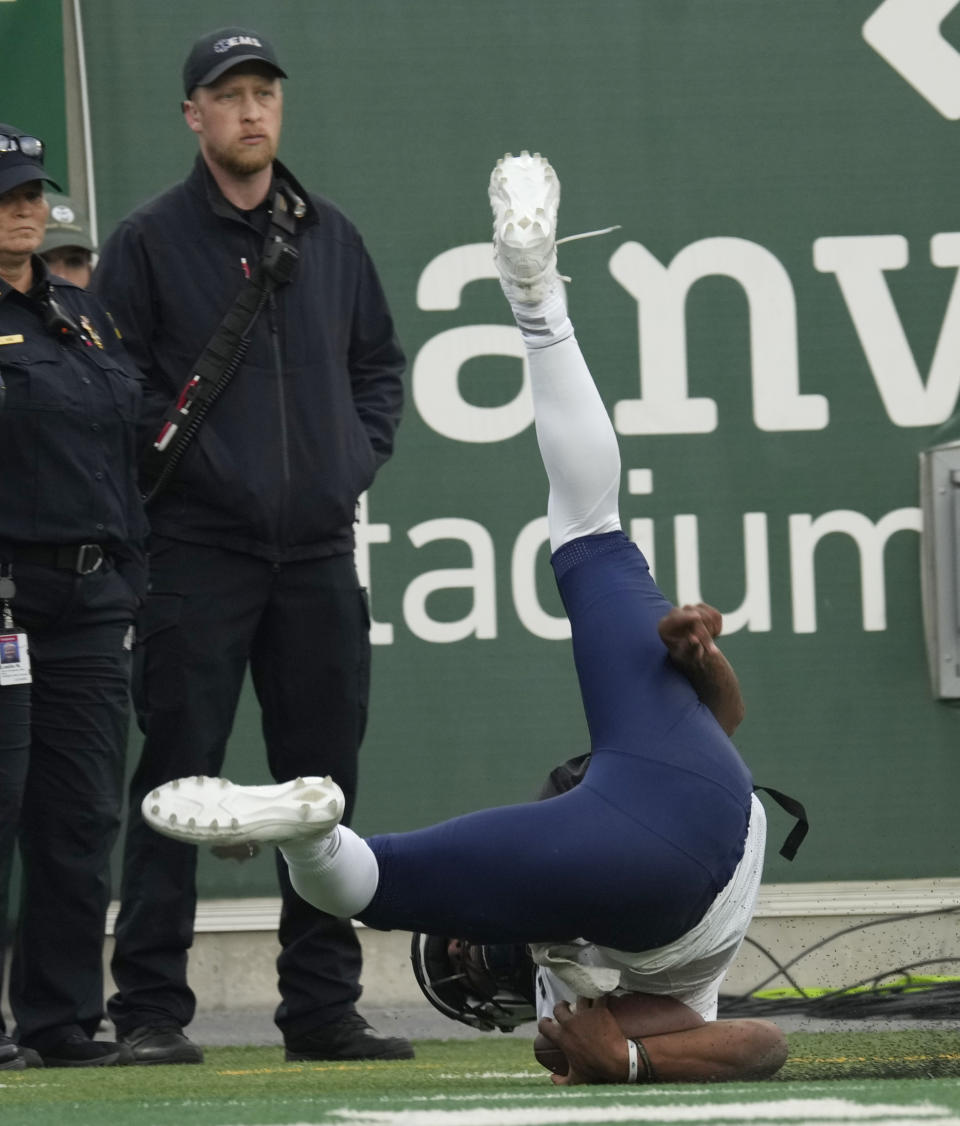 Nevada quarterback Brendon Lewis lands upside down after running for a touchdown against Colorado State in the second half of an NCAA college football game Saturday, Nov. 18, 2023, in Fort Collins, Colo. (AP Photo/David Zalubowski)