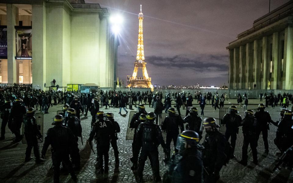 Riot police clear protesters gathered on Place du Trocadero near the Eiffel Tower  - Shutterstock