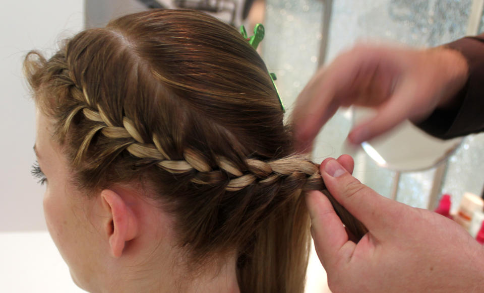 In this Aug. 1, 2012 photo, stylist Cliff Freeman braids the hair of Danielle Maddox, 25, at Maxine salon’s Braid Bar in Chicago. Salons from Los Angeles to New York and cities in between are opening "braid bars," offering special menus of different braid styles for a fixed price. (AP Photo/Caryn Rousseau)