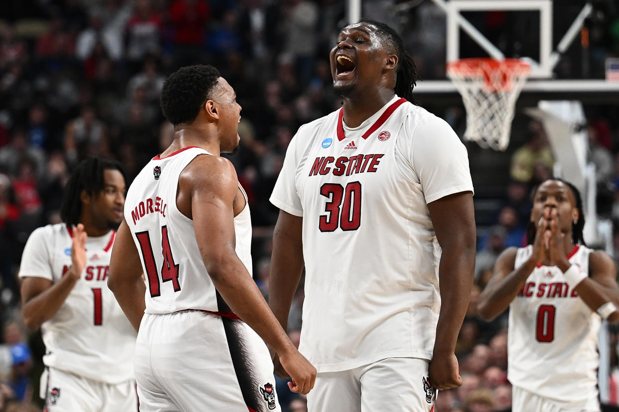 PITTSBURGH, PENNSYLVANIA - MARCH 23: DJ Burns Jr. #30 of the North Carolina State Wolfpack celebrates with Casey Morsell #14 after a basket in overtime of the game against the Oakland Golden Grizzlies during the second round of the 2024 NCAA Men's Basketball Tournament held at PPG PAINTS Arena on March 23, 2024 in Pittsburgh, Pennsylvania. (Photo by Justin Berl/NCAA Photos/NCAA Photos via Getty Images)