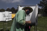 A man casts his vote in a non-binding referendum on whether Mexican ex-presidents should be tried for any illegal acts during their time in office, in San Miguel Topilejo, Mexico City, Sunday, August 1, 2021. (AP Photo/Christian Palma)