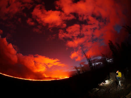 A USGS geologist making observations of the fissure 8 lava channel at sunset is pictured in this July 3, 2018 fisheye lens handout photograph near the Kilauea volcano eruption in Hawaii, U.S. USGS/Handout via REUTERS