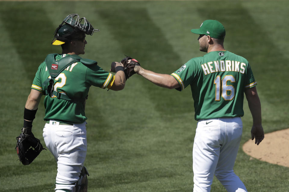 Oakland Athletics' Liam Hendriks (16) and Sean Murphy celebrate the team's 3-1 win over the Houston Astros in a baseball game Saturday, Aug. 8, 2020, in Oakland, Calif. (AP Photo/Ben Margot)