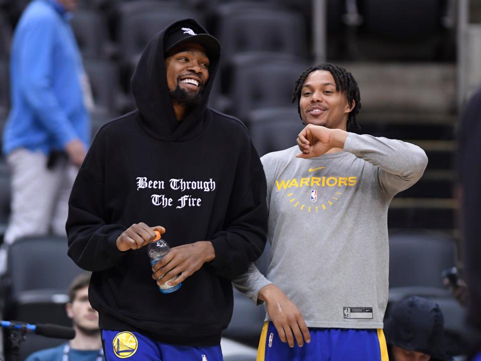 Golden State Warriors Kevin Durant, left, laughs with teammate Damion Lee during basketball practice at the NBA Finals in Toronto, Saturday, June 1, 2019. (Nathan Denette/The Canadian Press via AP)