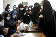 Women register to vote in the presidential election at a polling station in Tehran, Iran, Friday, June 18, 2021. Iran began voting Friday in a presidential election tipped in the favor of a hard-line protege of Supreme Leader Ayatollah Ali Khamenei, fueling public apathy and sparking calls for a boycott in the Islamic Republic. (AP Photo/Ebrahim Noroozi)