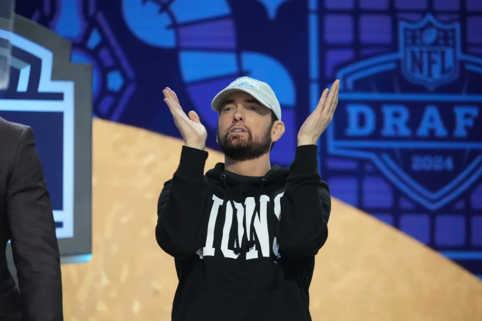 Eminem applauds on stage at the NFL Draft on April 25, the same day he announced his first album since 2020.