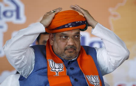 FILE PHOTO: India's ruling Bharatiya Janata Party (BJP) president Amit Shah adjusts a turban presented by his supporters during BJP workers meeting in Gandhinagar, in the western state of Gujarat, India, February 27, 2016. REUTERS/Amit Dave/File Photo