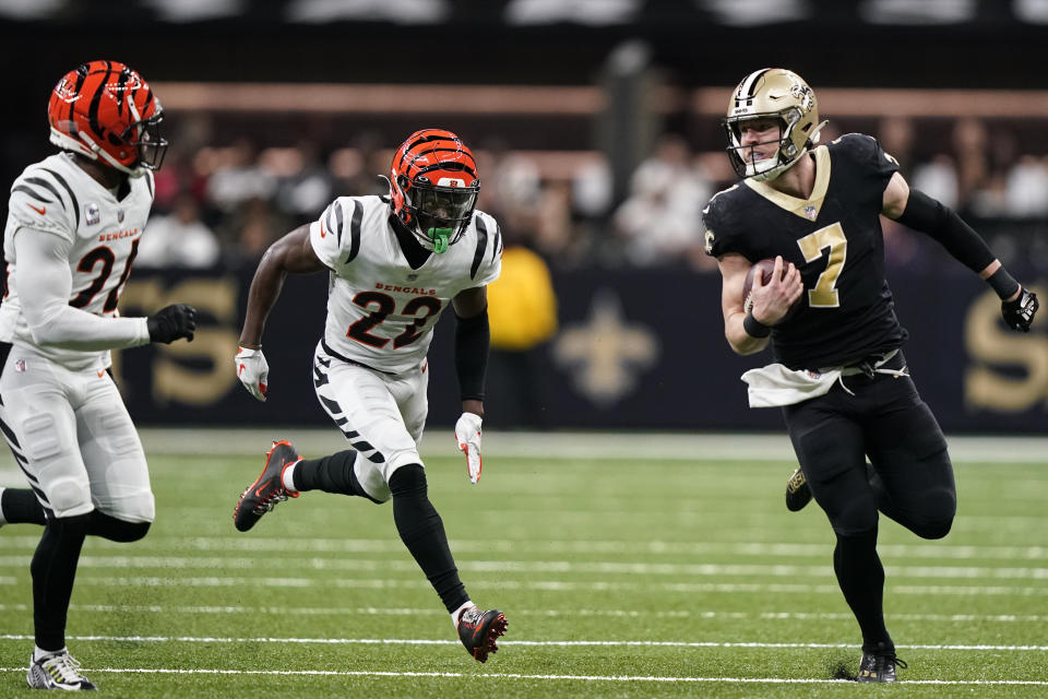 New Orleans Saints tight end Taysom Hill (7) runs for a long gain against Cincinnati Bengals players Chidobe Awuzie (22) and Vonn Bell (24) during the first half of an NFL football game in New Orleans, Sunday, Oct. 16, 2022. (AP Photo/Gerald Herbert)