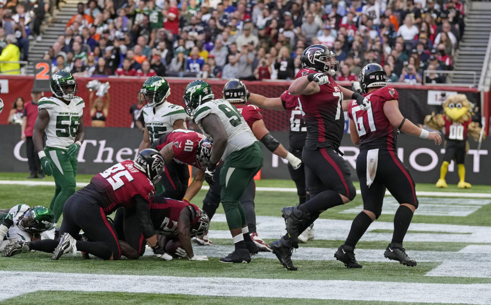 Atlanta Falcons celebrate after running back Mike Davis (28) scores a touchdown during the second half of an NFL football game between the New York Jets and the Atlanta Falcons at the Tottenham Hotspur stadium in London, England, Sunday, Oct. 10, 2021. (AP Photo/Alastair Grant)