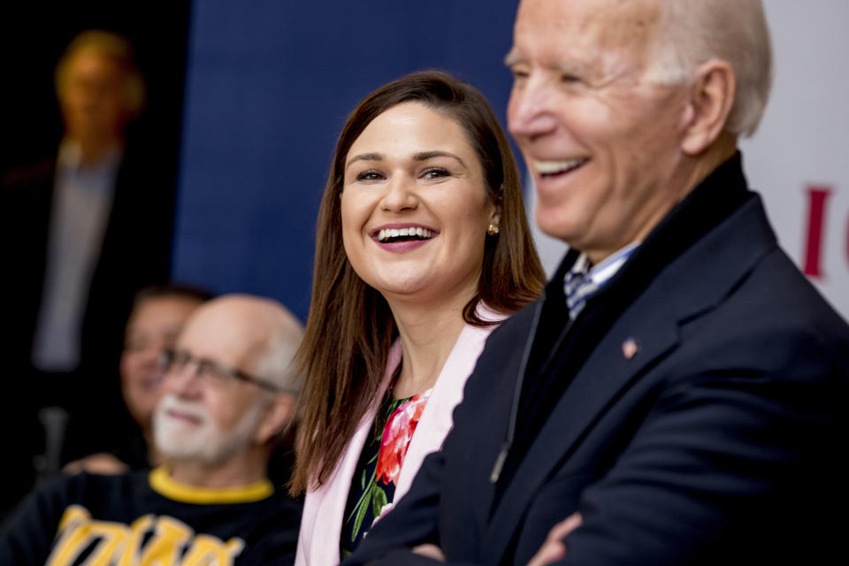 FILE - In this Friday, Jan. 3 2020 file photo, Democratic presidential candidate Joe Biden, right, and Rep. Abby Finkenauer, D-Iowa, center, smile during a campaign rally at the University of Dubuque, in Dubuque, Iowa. President-elect Joe Biden is eyeing several Democrats who lost congressional reelection races last month for key positions in his administration. They include outgoing Reps. Abby Finkenauer of Iowa and Donna Shalala of Florida and Sen. Doug Jones of Alabama. (AP Photo/Andrew Harnik)