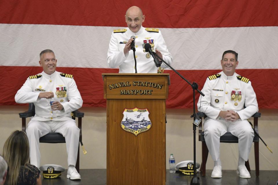 Rear Adm. Wesley McCall recounts a story during Friday's change of command ceremony with outgoing base commander Capt. Jason Canfield, left, and incoming commander Capt. Brian Binder, right, at Naval Station Mayport.