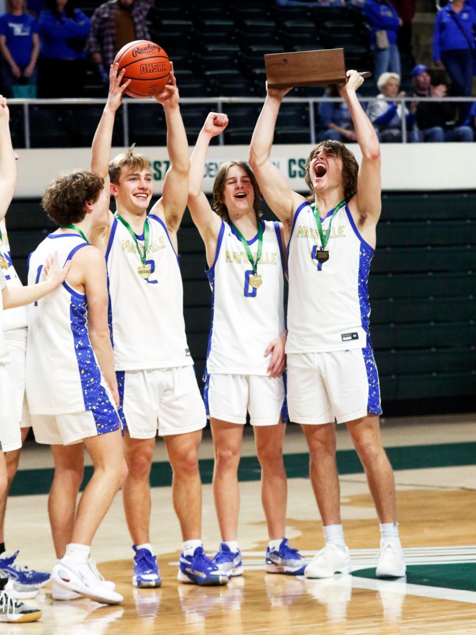 Maysville senior Alex Bobb, hoists the championship trophy with senior Wesley Armstead, left, and sophomore Gator Nichols following a 72-64 comeback win against Vincent Warren in a Division II regional final at the Ohio Convocation Center. The win secured Maysville's first state tournament berth since 1971.