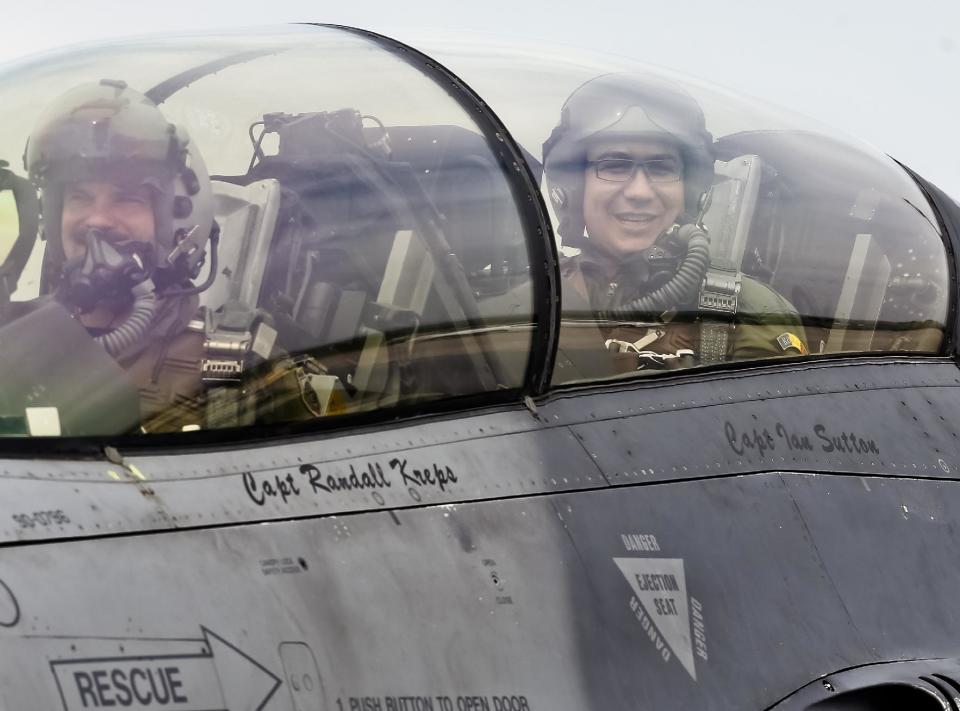 Romanian prime minister Victor Ponta, right, smiles from the cockpit of a US Air Force F-16 fighter jet piloted by Maj. Dustin Yogi Brown during a military exercise in Campia Turzii, Romania, Thursday, April 17, 2014. Dressed in a flight suit, Ponta visited the Campia Turzii military air base in northwest Romania where about 450 U.S. and Romanian troops and technical staff had been taking part in the weeklong exercises ending Thursday. (AP Photo/Mircea Rosca)