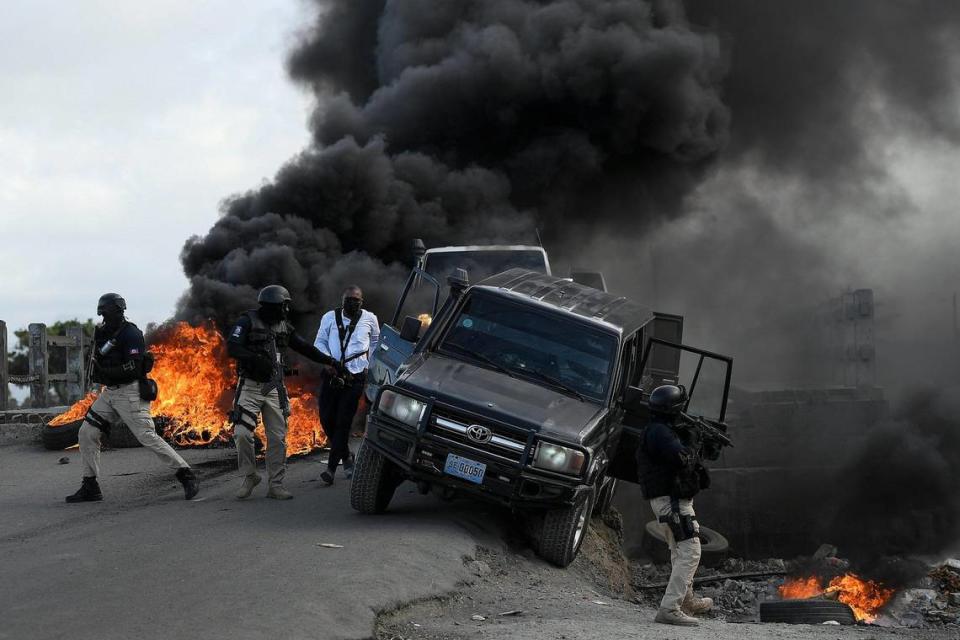 Police abandon their vehicle during a demonstration that turned violent in which protesters demanded justice for the assassinated President Jovenel Moise in Cap-Haitien, Haiti, Thursday, July 22, 2021. Demonstrations after a memorial service for Moise turned violent on Thursday afternoon with protesters shooting into the air, throwing rocks and overturning heavy concrete barricades next to the seashore as businesses closed and people took cover.