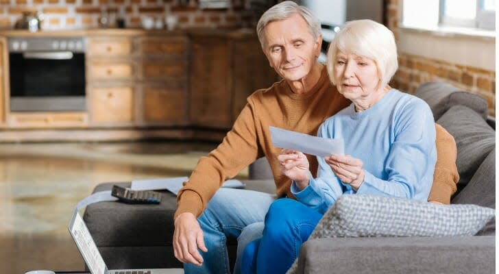 Una pareja de jubilados revisa un cheque del Seguro Social. Es posible obtener una hipoteca solo con los beneficios del Seguro Social, pero no tener ingresos regulares de un trabajo o cuentas de jubilación puede hacer que sea más difícil.