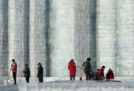 Workers clear up the melting ice on an ice sculpture at the venue of the Harbin International Ice and Snow Sculpture Festival on its closing day, in Harbin, Heilongjiang province, China February 17, 2019. Picture taken February 17, 2019. REUTERS/Stringer