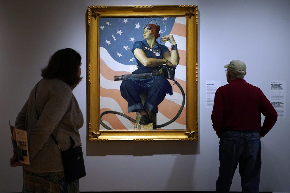 Visitors to the Crystal Bridges Museum of American Art view a painting titled "Rosie the Riveter" by Norman Rockwell, Wednesday, April 19, 2023, in Bentonville, Ark. General admission to the museum is free. (AP Photo/Sue Ogrocki)