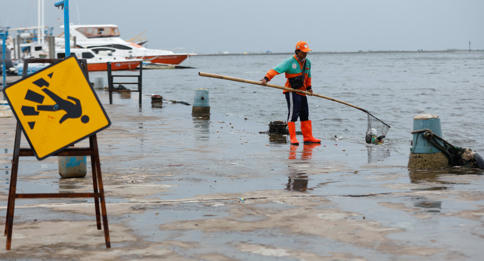 Municipal workers scoop up plastic from Jakarta's waters. Source: Reuters