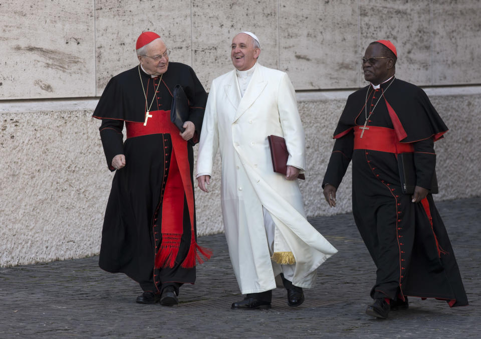 Pope Francis, flanked by cardinals Angelo Sodano, left, and Laurent Monsengwo Pasinya, as arrives to open the morning session of an extraordinary consistory in the Synod hall at the Vatican, Friday, Feb. 21, 2014. Pope Francis is leading a two-day meeting urging his cardinals to find "intelligent, courageous" ways to help families under threat today without delving into case-by-case options to get around Catholic doctrine. He said the church must find ways to help families with pastoral care that is "full of love."(AP Photo/Alessandra Tarantino)