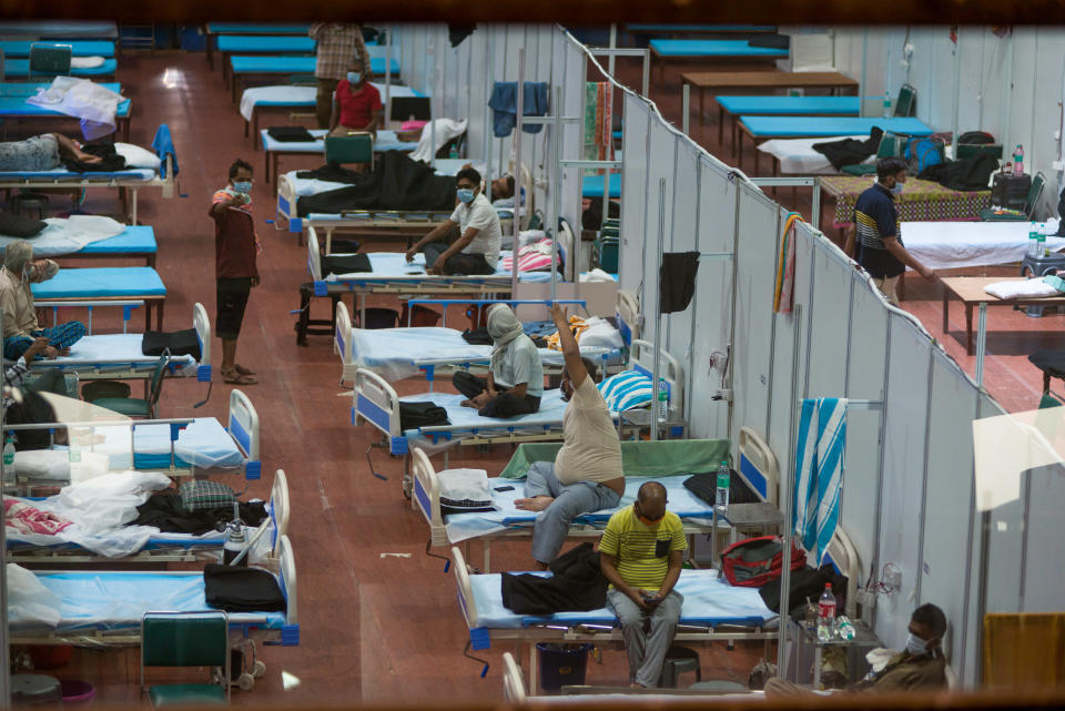 Patients are seen laying in a series of beds placed next to each other. 