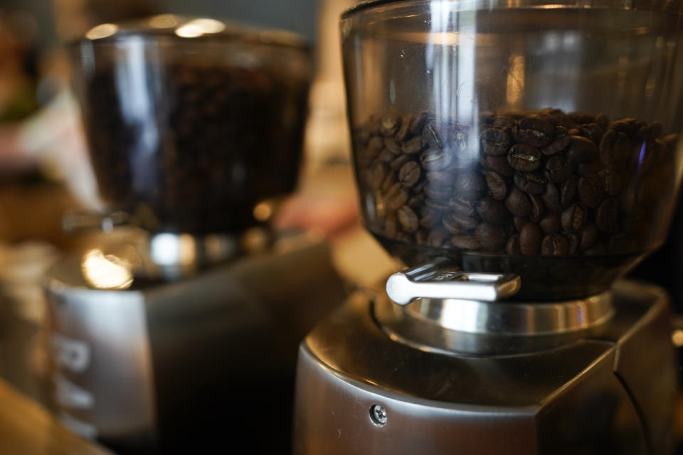 Coffee beans are seen in grinders at Vigilante Coffee, Wednesday, Sept. 1, 2021, in College Park, Md. A confluence of supply chain problems, drought, frost and inflation all point to the price of your cup of morning coffee going up. The tricky part is trying to figure when — and how much. A sustained drought followed by two July frosts blew a hole in Brazil's coffee output, sending futures contract prices for the popular Arabica bean to near seven-year highs. (AP Photo/Julio Cortez)