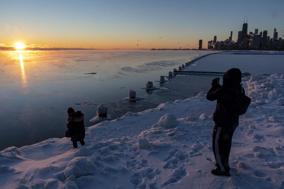 With temperatures below zero, photographers capture the sun rising over a frigid Lake Michigan and the Chicago skyline Sunday, Feb. 7, 2021. (Brian Cassella /Chicago Tribune via AP)