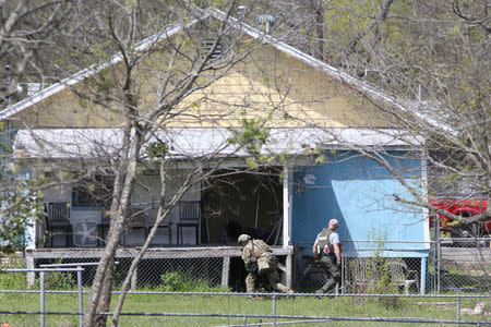 Law enforcement personnel investigate a home where the bomber was suspected to have lived in Pflugerville, Texas, U.S., March 21, 2018. REUTERS/Loren Elliott