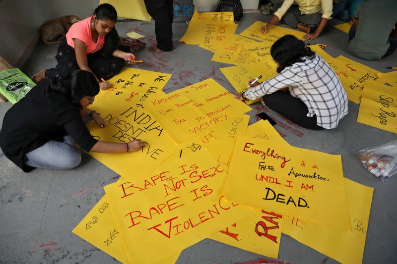 Students write placards before a protest against the alleged rape and murder of a 27-year-old woman, in Kolkata