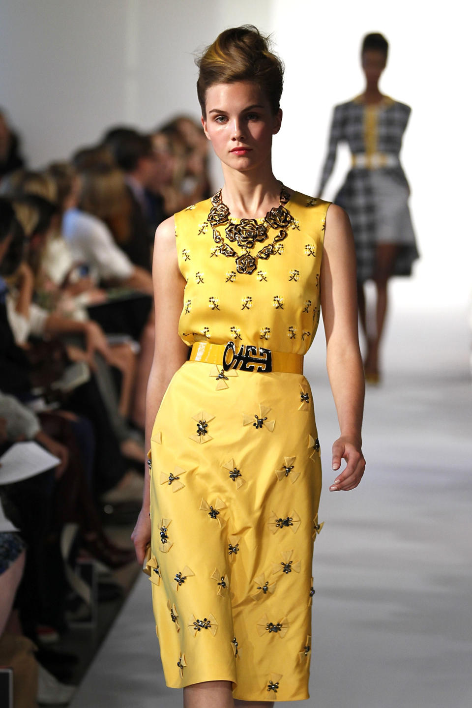 There’s a clear 1950s housewife vibe from this sunny yellow outfit, but the punky pompadour with dyed-to-match highlights gives it a modern twist.