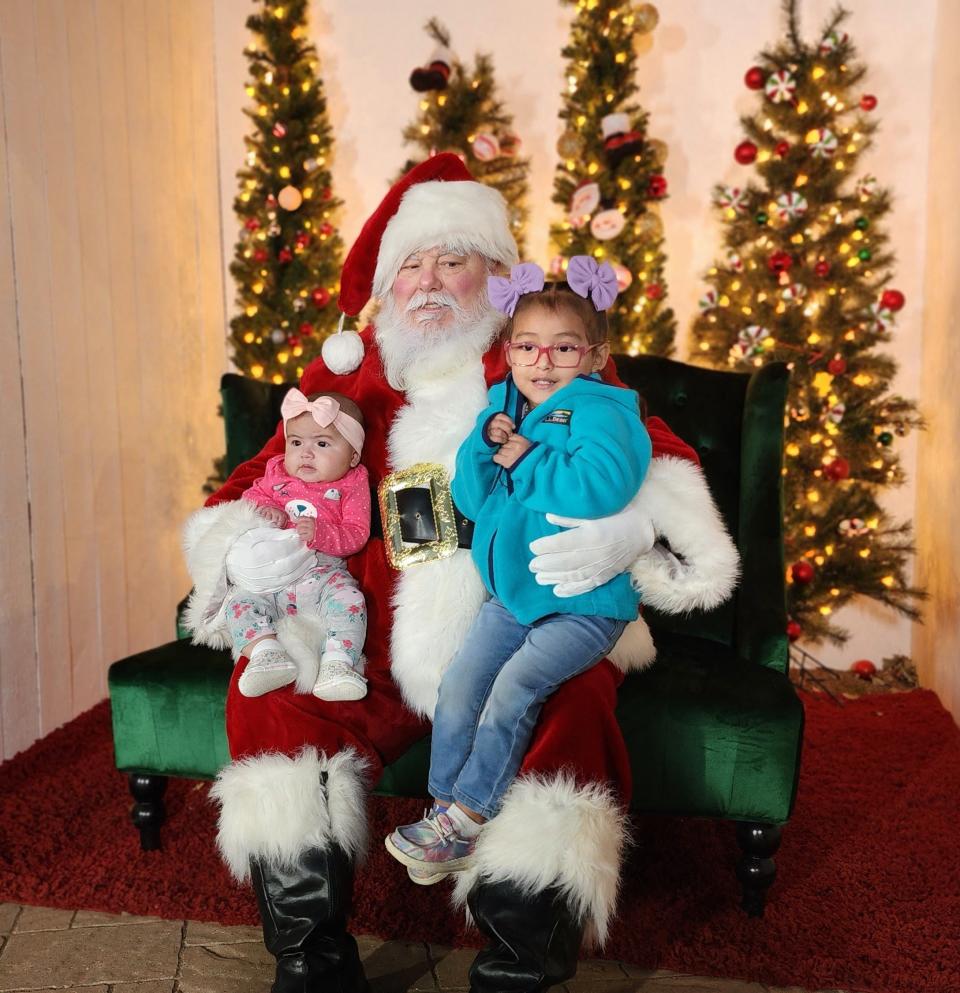 Jaylah and  Jaylynn Padilla take a picture with Santa Thursday at the Amarillo Botanical gardens during its Christmas in the Garden event