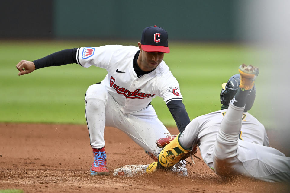 Cleveland Guardians' Brayan Rocchio tags out Oakland Athletics' Esteury Ruiz at second base as Ruiz attempted to stretch a single into a double during the fifth inning of a baseball game Saturday, April 20, 2024, in Cleveland. (AP Photo/Nick Cammett)