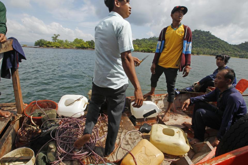 In this Nov. 27, 2016, photo, members of a seahorse conservation team search a Vietnamese fishing boat near the coast of Koh Ach Seh Island near the Cambodia-Vietnam border. Off a remote Cambodian island, conservationists are battling against illegal fishermen to save an iconic species, the seahorse. The much-loved figure of ancient legends has been around for 40 million years but is now being ruthlessly exploited for Asian traditional medicine. (AP Photo/Heng Sinith)