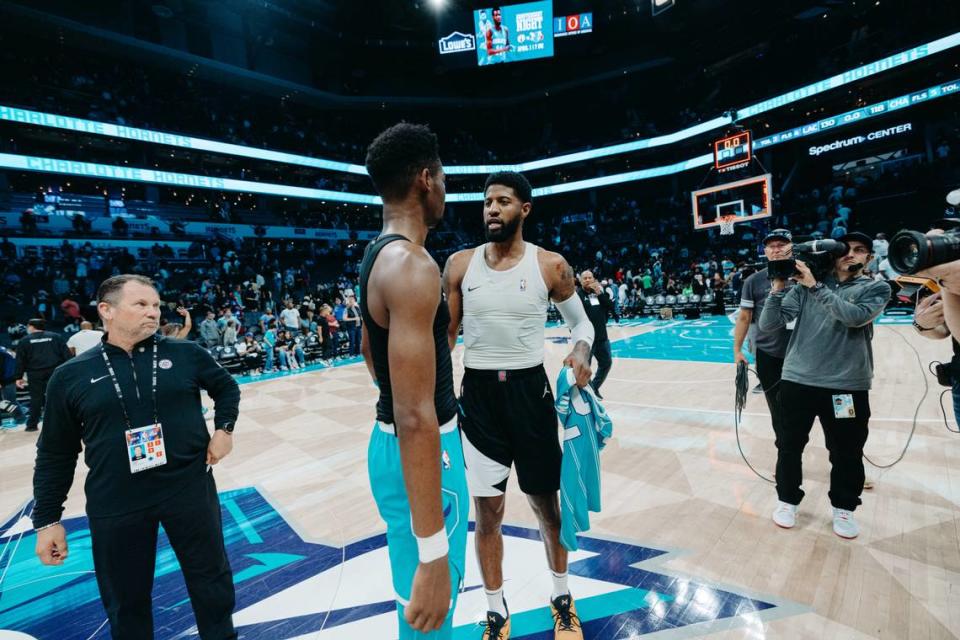 Charlotte Hornets rookie Brandon Miller (center) chats with LA Clippers star Paul George after Sunday night’s game at Spectrum Center. The Hornets lost 130-118.