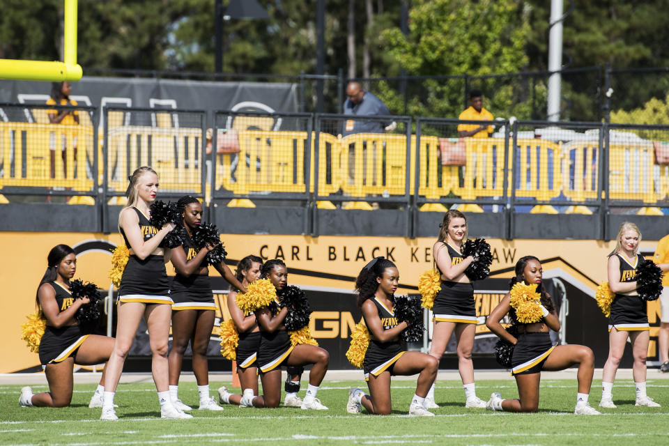 Five Kennesaw State University cheerleaders take a knee during the national anthem prior to a college football game on Sept. 30. (Atlanta Journal-Constitution via AP)