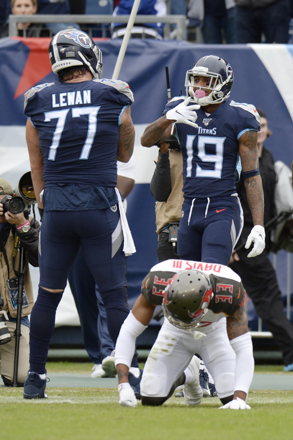 Tennessee Titans wide receiver Tajae Sharpe (19) celebrates with offensive tackle Taylor Lewan (77) after Sharpe beat Tampa Bay Buccaneers cornerback Carlton Davis (33) on a touchdown catch in the first half of an NFL football game Sunday, Oct. 27, 2019, in Nashville, Tenn. (AP Photo/Mark Zaleski)