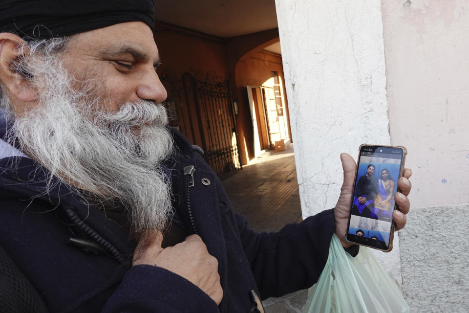 Swaranjit Singh Ghotra, photographer and wedding planner for Indian and Pakistani couples shows pictures of married couples from his Instagram account, in Brescia, Italy, Wednesday, Feb. 8, 2023. He said he receives many requests for arranged marriages that both spouses want. But courageous refusal by young immigrant women in Italy to submit to forced marriages sometimes carries a deadly price. In two murder trials this month, Italian prosecutors are seeking justice for Pakistani immigrant women allegedly killed because they refused marriages imposed by their parents. (AP Photo/Luca Bruno)