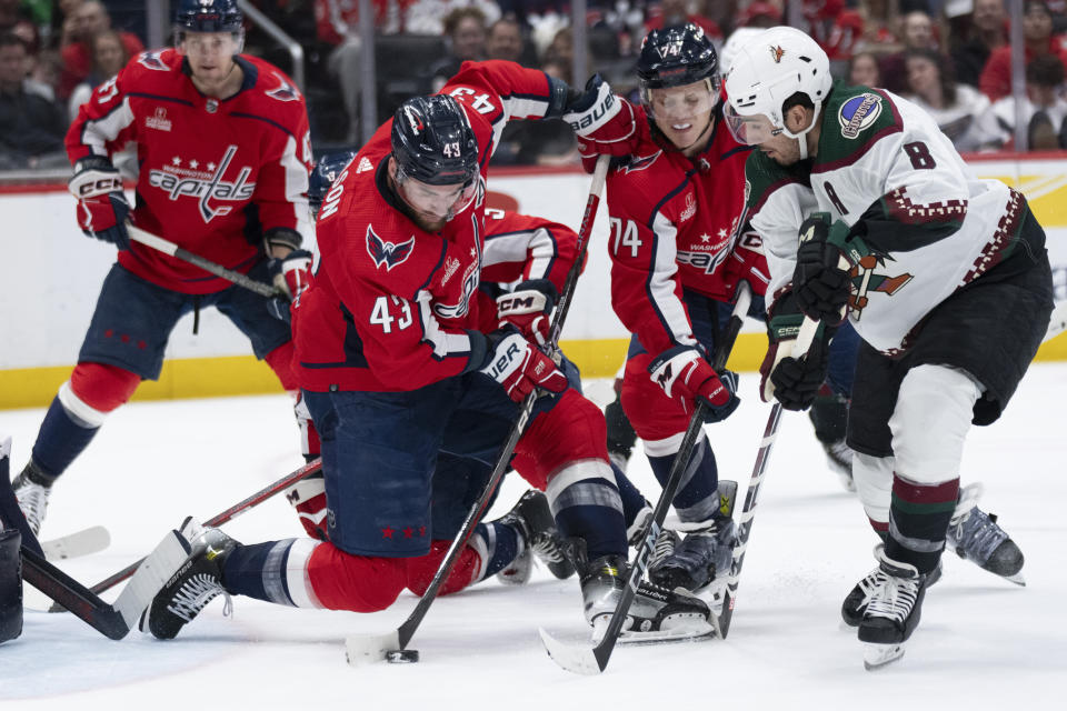 Washington Capitals right wing Tom Wilson (43) hits the puck away from his goal and Arizona Coyotes center Nick Schmaltz (8) during the second period of an NHL hockey game, Sunday, March 3, 2024, in Washington. (AP Photo/Manuel Balce Ceneta)