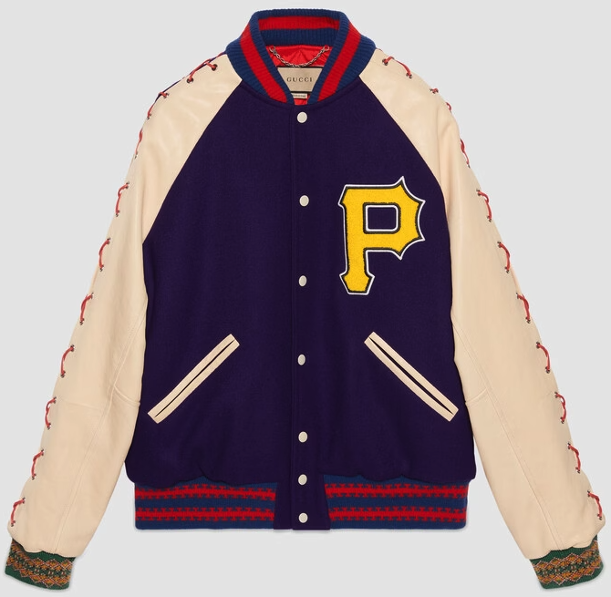 blue and cream bomber jacket with red stitching and yellow pirate patch