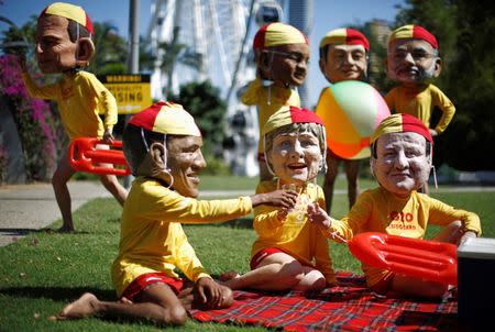 Protesters, wearing masks depicting G20 leaders, and dressed as Australian surf lifesavers call for global equality among nations outside the venue site of the annual G20 leaders summit in Brisbane, November 14, 2014. Jason Reed / Reuters